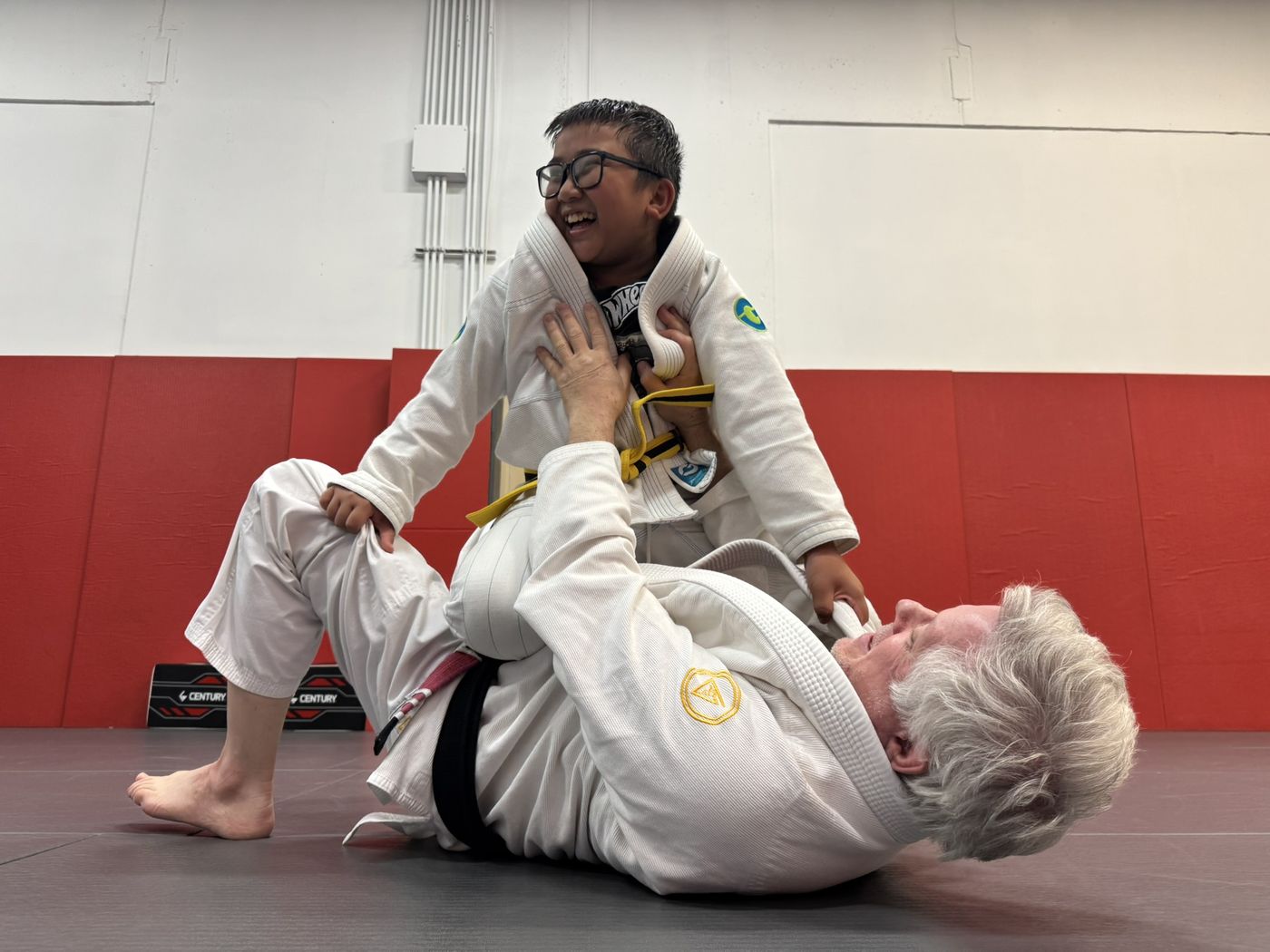 Kids Jiu-Jitsu student laughing during a knee-on-belly drill at Invictus
